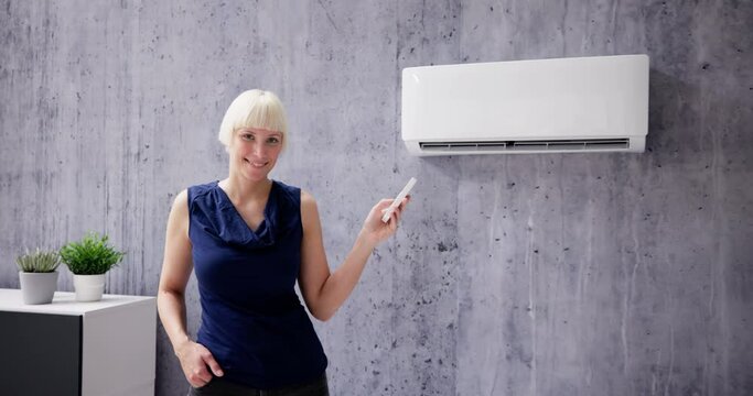 Happy Woman Using Air Conditioner At Home