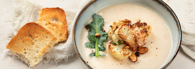 Roasted cauliflower soup served with grilled bread.