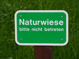 Schild mit Aufschrift Naturwiese bitte nicht betreten