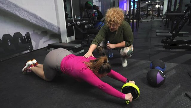 Two beautiful, overweight women push their limits during a workout, supporting each other every step.	

