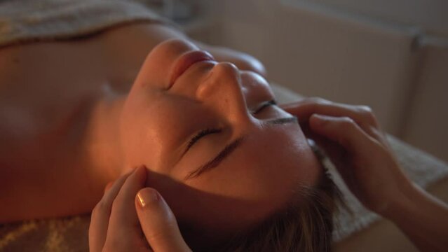Body massage treatment. Woman having face massage in the spa salon. 
