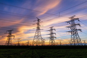 In the evening, the silhouette of high voltage towers