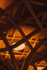 The wood-paneled ceiling with wooden beams lining. Part of the wooden architecture of the building interior.