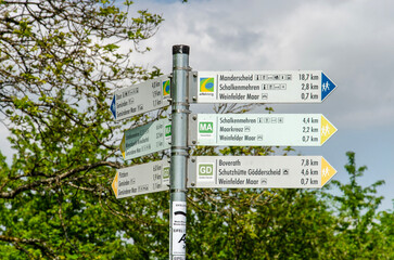 Daun, Germany, May 26, 2023: pole with signs indicating hiking trail around the Maare crater lakes