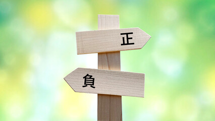 正と負の文字入り道しるべと緑ボカシ