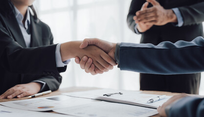 Entrepreneurs collaboration deal shaking hands in a modern office. Business people shaking hands finishing up a meeting.