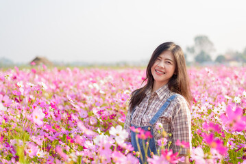 Relaxed happy and carefree pretty asian woman at flower garden in Chiangmai, concept photo of travel and freedom.