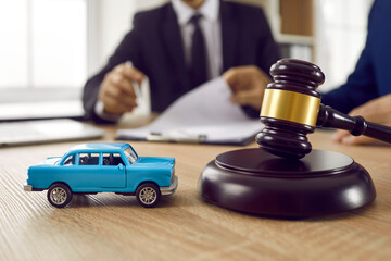 Close up of barrister and car model on table in legal advisor office. Notary professional consult...
