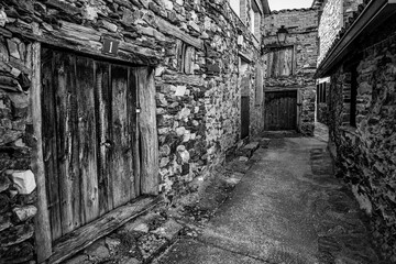 Old stone houses forming a narrow alley in an old village of Madrid, Puebla de la Sierra.