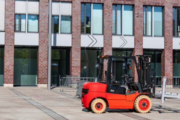 Forklift at a construction site against the backdrop of a large building. Side view.