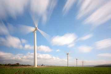 A group of wind turbine and a long exposure of a clouds 
