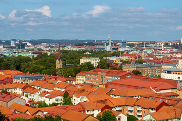 Fototapeta na wymiar Aerial view of the Haga church (Hagakyrkan) in Gothenburg, Sweden surrounded by red rooftops and green trees.