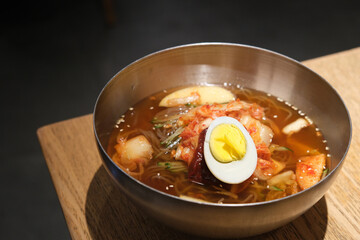 close up a bowl of Naengmyeon (raengmyŏn) on table. Traditional Korean noodles dish