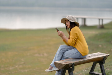 Woman camping, she is searching for internet signal.