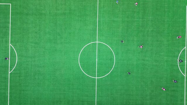 선수들이 분주히 공을 따라 뛰어다니는 대학교 축구경기장
