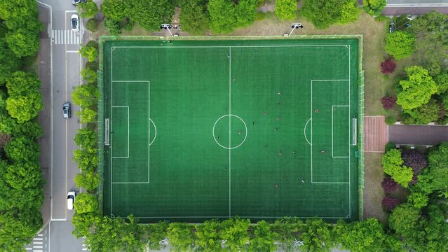선수들이 분주히 공을 따라 뛰어다니는 대학교 축구경기장