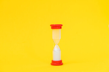 Hourglass from a board game on a yellow background