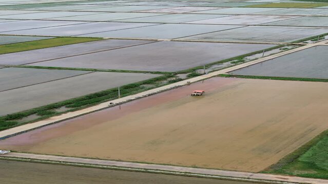 모내기철을 맞이한 바둑판 모양의 논에 물을 대고 흙을 갈아엎는 농기계