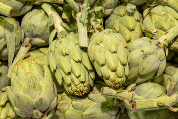 Fototapeta premium Fresh artichokes in the market. Delicious plant-based food.