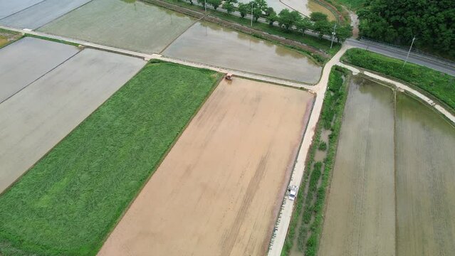 모내기철을 맞이한 바둑판 모양의 논에 물을 대고 흙을 갈아엎는 농기계