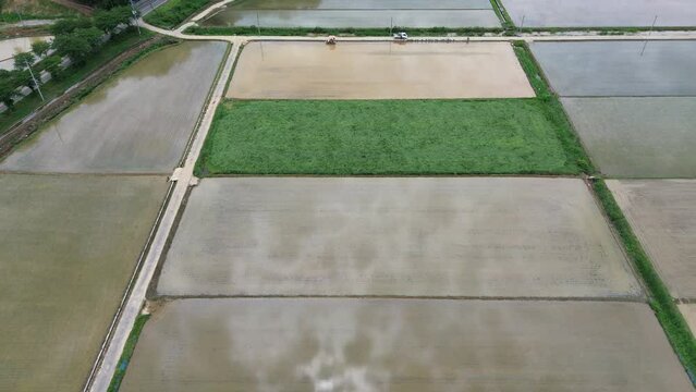 모내기철을 맞이한 바둑판 모양의 논에 물을 대고 흙을 갈아엎는 농기계