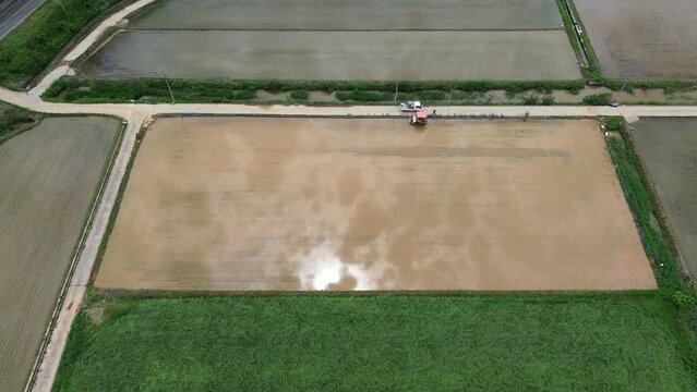 모내기철을 맞이한 바둑판 모양의 논에 물을 대고 흙을 갈아엎는 농기계