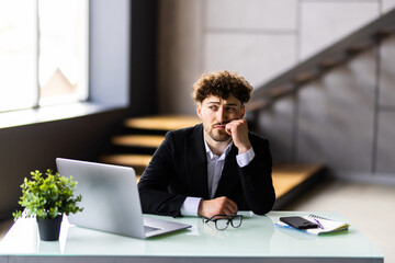 Fototapeta premium Young businessman typing on laptop at workplace