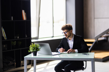 Businessman taking notes while working in the office.