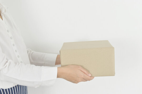 Woman Hand Holding Cardboard Box On White Background.