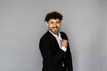 Businessman smiling with arms on gray background