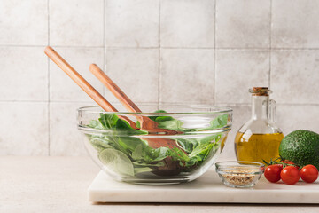 Fresh green lettuce leaves mix in glass bowl. Cooking healthy and delicious food. Diet food concept