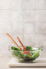 Fresh green lettuce leaves mix in glass bowl. Cooking healthy and delicious food. Diet food concept