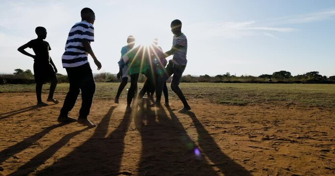 Poverty. Slow motion. Poor Black African children playing soccer in a township slum