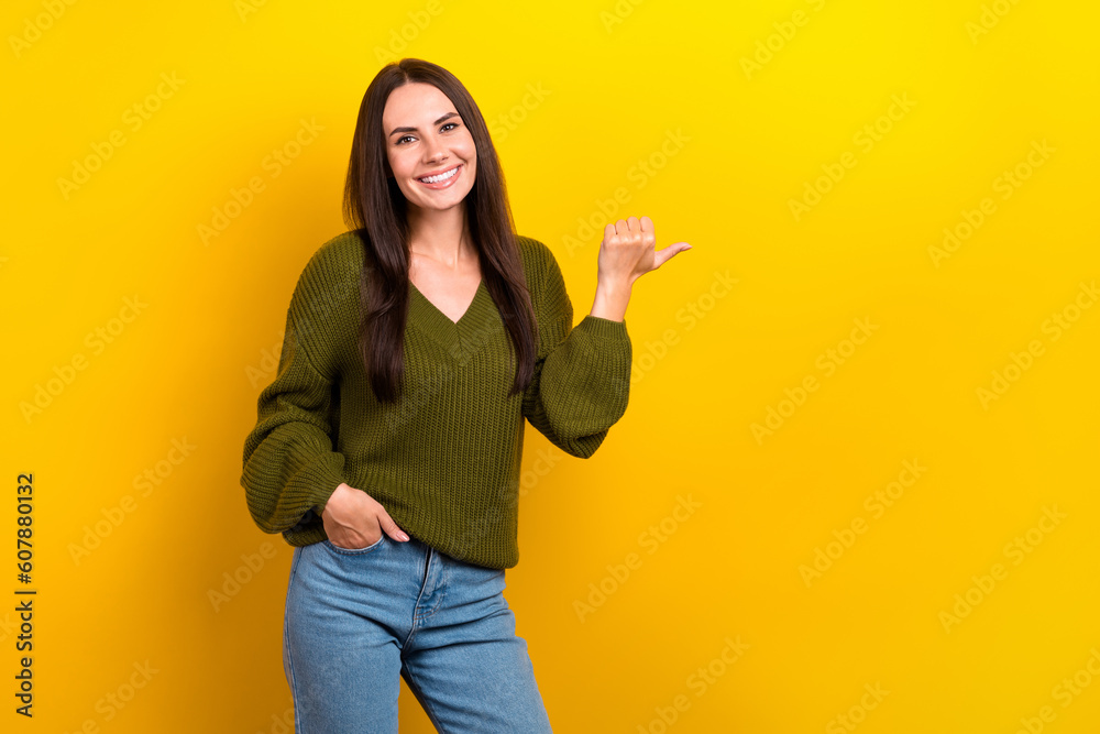 Poster Photo of pretty positive person indicate thumb finger empty space ad isolated on yellow color background