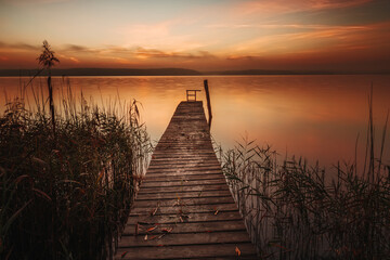 Sonnenaufgang über einem Bootssteg am Ufer des Plauer Sees in Plau am See in der Mecklenburgischen Seenplatte - obrazy, fototapety, plakaty