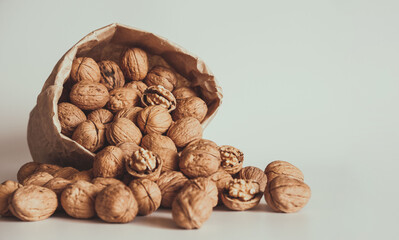 Walnut in a paper bag on a white background. Natural ingredient. Close-up, shopping grocery concept, nuts delivery. Zero Waste Food Shopping. Copy space