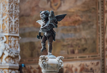Sculpture of cupid with dolphin in the inside contryyard of a Palazzo Vecchio palace in the old Florence town, Italy.