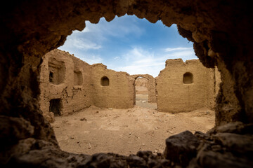 view from a hole in the wall on the ancient house ruins in the desert in iran