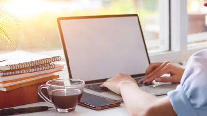 Young Asian businesswoman using laptop and notebook computers to work through internet to collect and organize investment documents. young businesswoman concept using technology to help investment