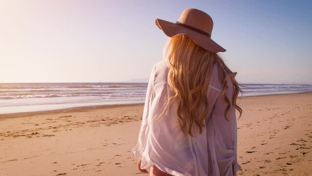 Attractive blond woman at the beach at sunset in Southern California. Slow Motion.