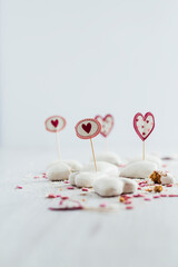 Heart shaped white cookies and toothpicks on white