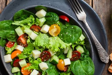Salad of spinach, cherry tomatoes and cheese in a plate
