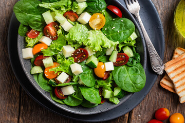 Salad of spinach, cherry tomatoes and cheese in a plate