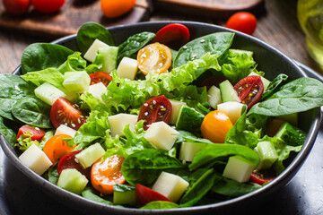 Salad of spinach, cherry tomatoes and cheese in a plate