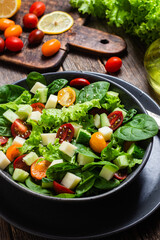 Salad of spinach, cherry tomatoes and cheese in a plate