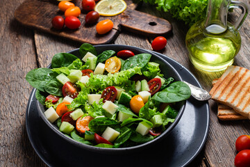Salad of spinach, cherry tomatoes and cheese in a plate