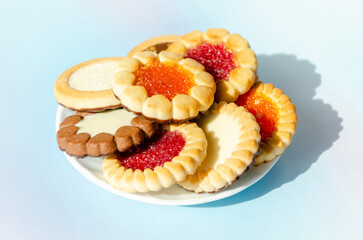 cookies on plate against blue background. round cookies laid out on saucer. copy space, top view