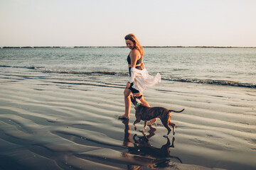 woman walking her dog on the beach
