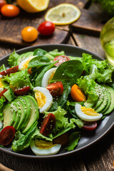 Salad with spinach, avocado, tomatoes in a plate. Vegetarian salad