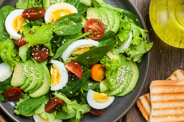 Salad with spinach, avocado, tomatoes in a plate. Vegetarian salad